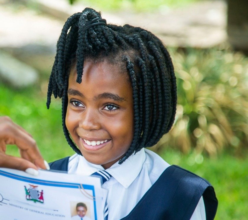 A Tutor PMB pupil in Pietermaritzburg smiling as she holds up a marked test